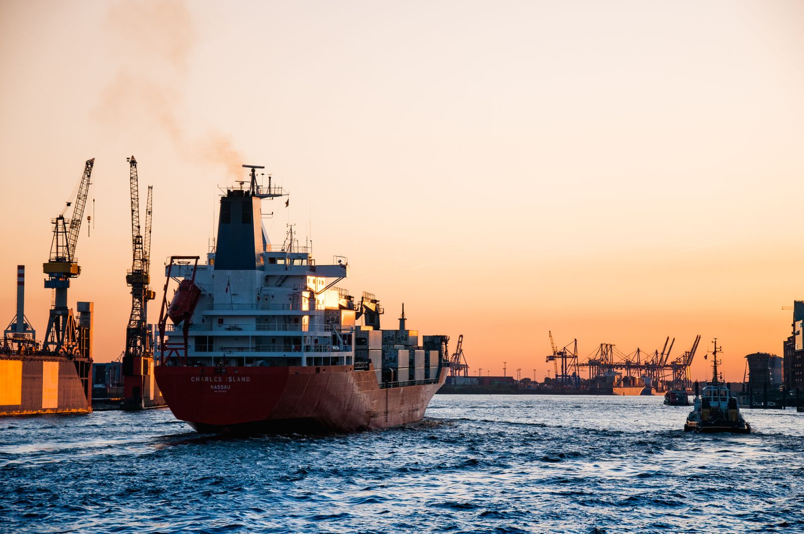 Navio cargueiro deixando o porto ao pôr do sol